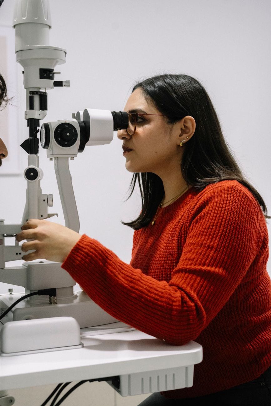 An optometrist working at a slit lamp